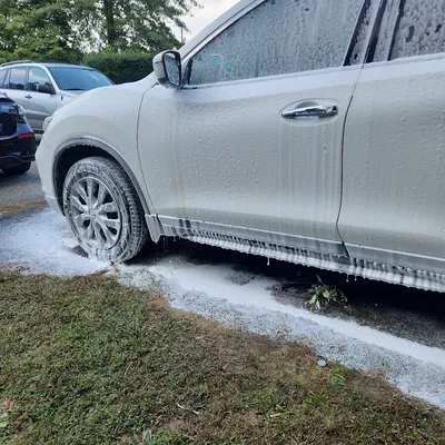 White SUV covered in foam during an exterior wash by Eagle Eye Auto Detailing