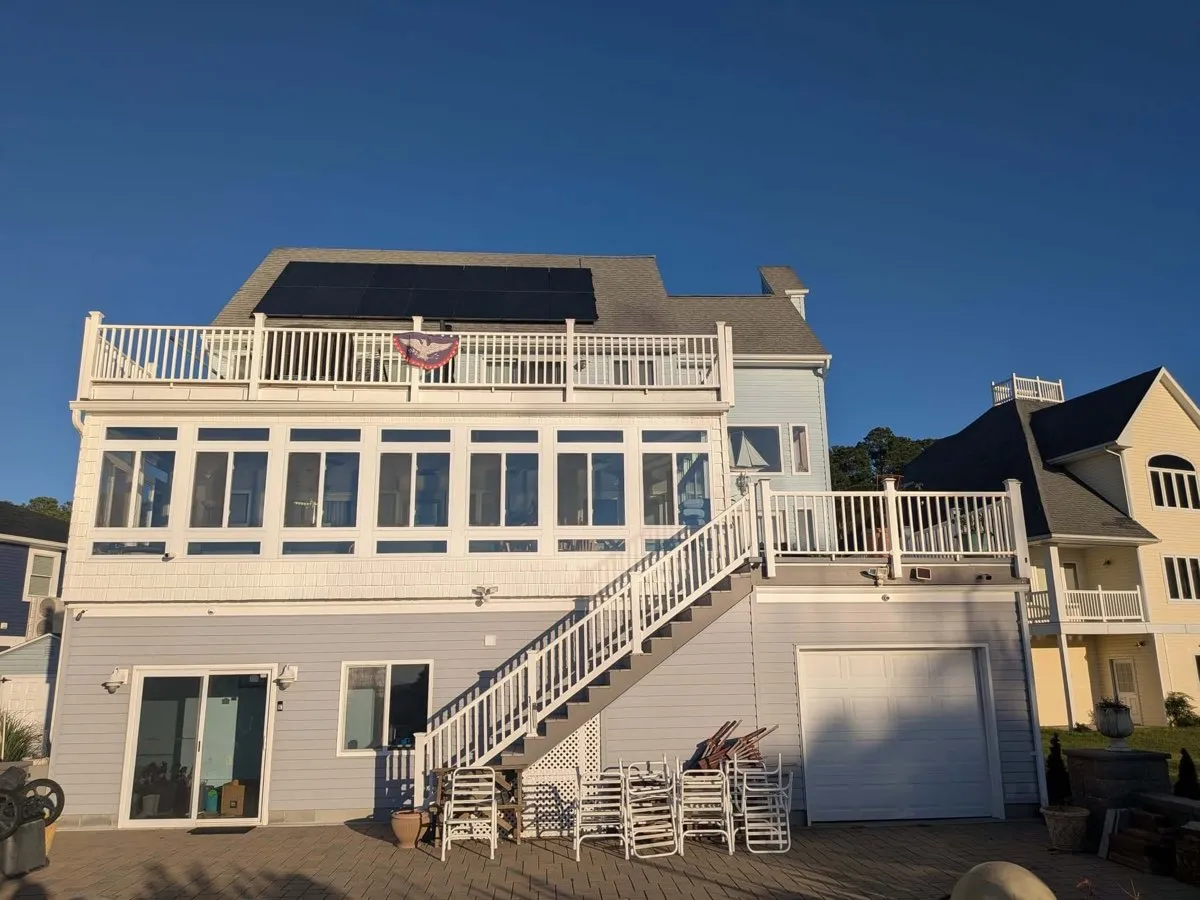 Completed home exterior with solar panels and a new deck by Eastern Shore Roofing and Remodeling in Snow Hill, MD