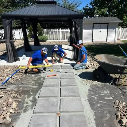 Elzey Services crew installing a paver stepping stone walkway near a backyard gazebo in Delmar, MD
