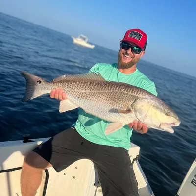 Angler holding a large redfish caught on a FishPit Charters trip