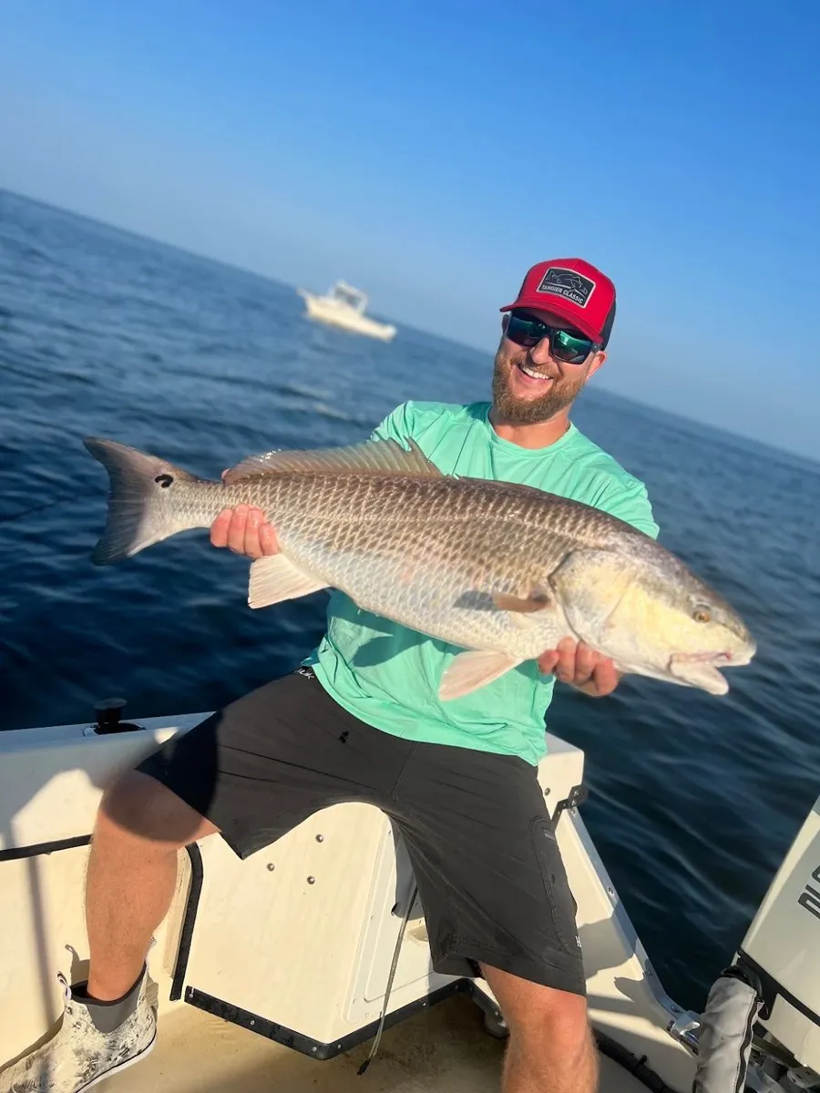 Angler holding a large redfish caught on a FishPit Charters trip