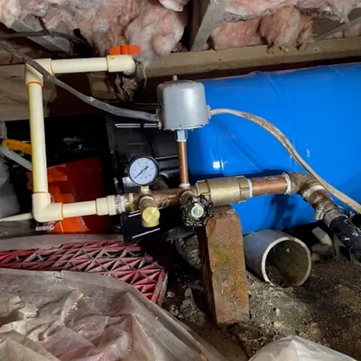 Well pressure tank and pump system installed in a crawlspace by Legar & Son Plumbing in Salisbury, MD
