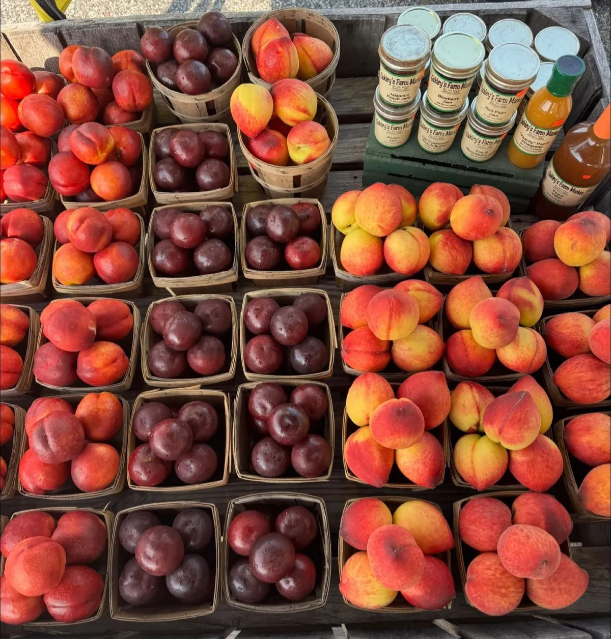 Baskets of peaches and plums next to jars of homemade jam at Oakley's Farm Market in Hebron, MD