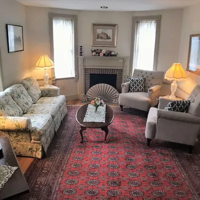 Historic Victorian parlor with a floral sofa and fireplace at The Parsonage Inn in St. Michaels, MD